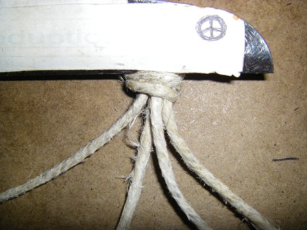 Fasten the knot to the top of the clipboard.  The left and right side cords are the tying cords and the middle two cords are the anchor cords.
